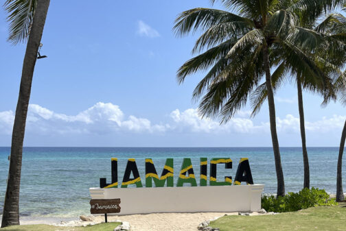 Jamaica sign in the Jamaican flag colors in front of the seaside at the Hyatt Ziva Rose Hall.