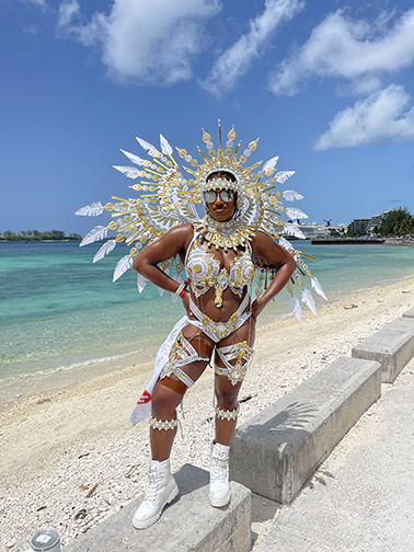 The author standing on a concrete barrier at Junkanoo beach in her Bahamas Masqueraders Amun-Ra costume designed by Anthony Knowles for Bahamas Carnival.