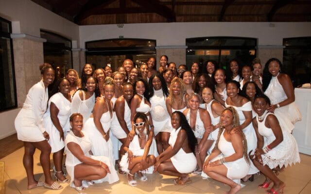 40 Black women all wearing white taking a group picture together